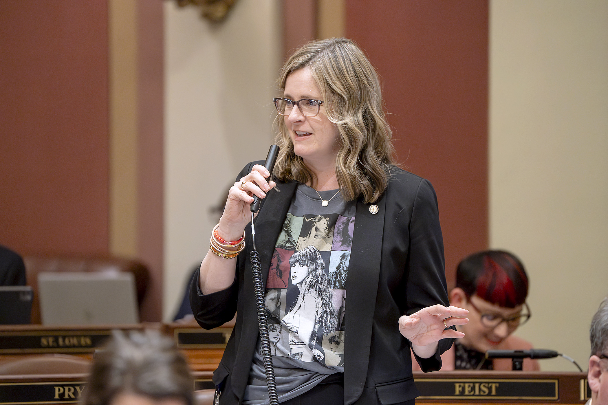 Rep. Kelly Moller — wearing a Taylor Swift t-shirt — introduces HF1989 during an April 11 floor session. (Photo by Michele Jokinen)
